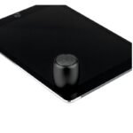 Kompakter schwarzer Mini-Lautsprecher aus Aluminium mit Firmenlogo